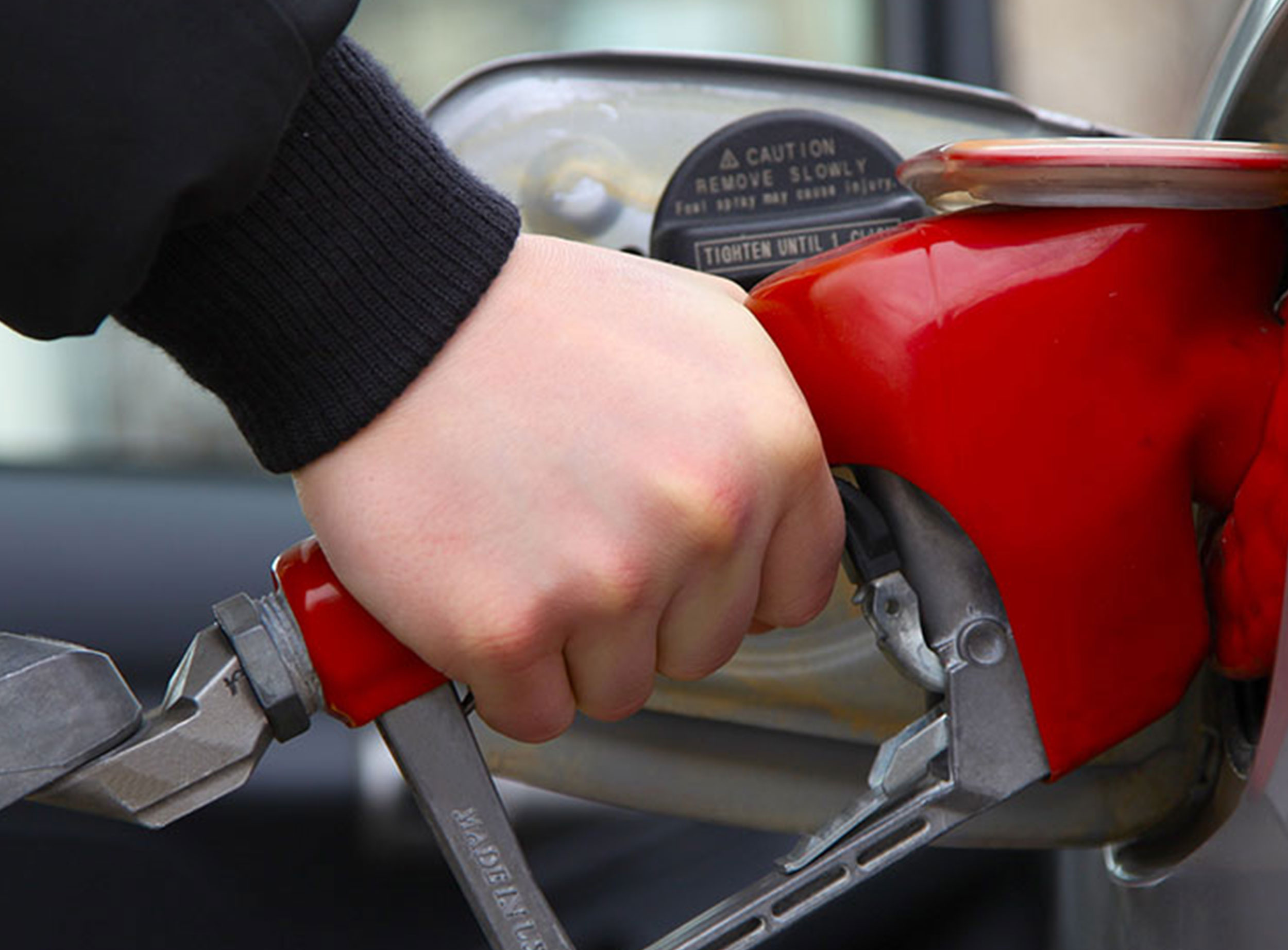 image of hand pumping gas into vehicle