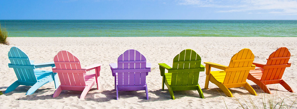 colorful chairs sitting in the sand on a beach
