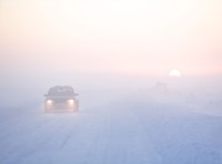 image of car on snow-covered road at sunrise