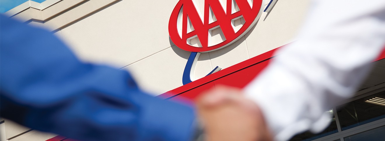 Welcome handshake with AAA building in background